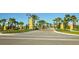 Community entryway featuring manicured landscaping, decorative pillars, and palm-lined streets for a grand arrival at 12133 Forest Park Cir, Bradenton, FL 34211