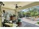 Lanai with a ceiling fan, outdoor seating, a pond with a waterfall feature, and a view of tropical plants at 12133 Forest Park Cir, Bradenton, FL 34211