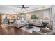 Open-concept living room with hardwood floors, comfortable seating, and adjacent dining and kitchen areas at 12133 Forest Park Cir, Bradenton, FL 34211