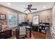 Home office featuring built-in shelves, wood floors, a ceiling fan, and a desk facing a large window with shutters at 12133 Forest Park Cir, Bradenton, FL 34211
