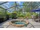 Enclosed pool area with a spa, blue umbrella, table and chairs, and tropical landscaping at 12133 Forest Park Cir, Bradenton, FL 34211