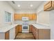 Bright kitchen featuring white appliances and wooden cabinets with wood laminate flooring at 12358 Destiny Dr, Venice, FL 34292