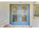 Elegant blue double front doors with decorative glass and gold trim, creating a grand entrance at 127 Colonial Sw St, Port Charlotte, FL 33952