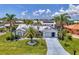 Inviting home with lush lawn, palm trees, and a well-maintained exterior, including a two car garage and solar panels at 127 Colonial Sw St, Port Charlotte, FL 33952