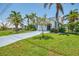 Charming home with lush green lawn, palm trees, and a neatly kept exterior, showcasing curb appeal at 127 Colonial Sw St, Port Charlotte, FL 33952