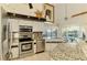 Bright kitchen showcasing stainless appliances, granite countertops, and ample cabinet space at 127 Colonial Sw St, Port Charlotte, FL 33952