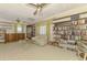 Spacious living room featuring a couch, bookshelves, display cabinet and ceiling fans at 127 Colonial Sw St, Port Charlotte, FL 33952