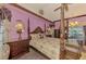 Purple-painted bedroom featuring a canopy bed and wood floors that flow to a view of the outdoors at 127 Colonial Sw St, Port Charlotte, FL 33952
