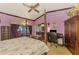 Purple-painted bedroom featuring a canopy bed, wood floors, and a purple chaise lounge at 127 Colonial Sw St, Port Charlotte, FL 33952