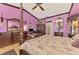 Purple-painted bedroom featuring a canopy bed, wood floors, and an archway to the ensuite bath at 127 Colonial Sw St, Port Charlotte, FL 33952