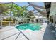 Enclosed pool area surrounded by lush landscaping and palm trees and featuring canal views at 127 Colonial Sw St, Port Charlotte, FL 33952