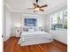 Bright bedroom features hardwood floors, a ceiling fan, and a view of the lush outdoors at 1313 Thornapple Dr, Osprey, FL 34229