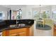 Granite countertop with a stainless steel sink and view into the breakfast nook with large windows at 1313 Thornapple Dr, Osprey, FL 34229