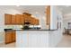 Open kitchen featuring wood cabinets, black countertops, and a breakfast bar with white paneled wainscoting at 1313 Thornapple Dr, Osprey, FL 34229