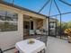 Stylish screened patio featuring outdoor seating and a tranquil garden backdrop at 1313 Thornapple Dr, Osprey, FL 34229