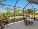 Relaxing screened patio with outdoor dining and beautiful backyard views at 1313 Thornapple Dr, Osprey, FL 34229