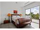 Cozy bedroom featuring a wood sleigh bed, stylish lamps, and a view of the trees at 1365 Harbor Dr, Sarasota, FL 34239