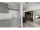 Open concept living space featuring a wet bar with marble backsplash and modern gray cabinetry at 1365 Harbor Dr, Sarasota, FL 34239