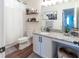 Stylish bathroom with granite counters, modern fixtures, and decorative shelving over toilet at 14363 59Th E Cir, Lakewood Ranch, FL 34211