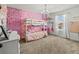Charming bedroom with bunk beds, pink accents, decorative wall, and a chandelier at 14363 59Th E Cir, Lakewood Ranch, FL 34211