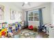 Bright playroom featuring a ceiling fan, laminate flooring, and blue curtains at 14363 59Th E Cir, Lakewood Ranch, FL 34211