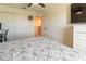 Bright bedroom featuring a ceiling fan, TV, and double door closet at 14363 59Th E Cir, Lakewood Ranch, FL 34211