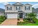 Traditional two-story home featuring manicured lawn, palm tree, and paver driveway at 14363 59Th E Cir, Lakewood Ranch, FL 34211