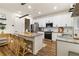 Modern kitchen features white cabinets, stainless steel appliances, and a granite-topped island with seating at 14363 59Th E Cir, Lakewood Ranch, FL 34211