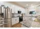 Modern kitchen features stainless steel appliances, granite countertops, white cabinets, and stylish backsplash at 14363 59Th E Cir, Lakewood Ranch, FL 34211
