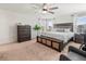 Bright main bedroom featuring a ceiling fan, large windows, and a king-size bed with storage at 14363 59Th E Cir, Lakewood Ranch, FL 34211