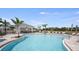 Community pool with ample seating and shade near a charming clubhouse in a tropical setting at 15140 Cuzcorro Ct, Nokomis, FL 34275