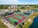 A high angle view of community tennis courts, parking area and adjacent lakeside buildings at 175 Kings Hwy # B5, Punta Gorda, FL 33983