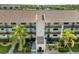 Overhead view of a condo building featuring a tan roof, palm trees, and well-kept grounds at 175 Kings Hwy # B5, Punta Gorda, FL 33983