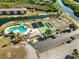 Aerial view showcasing a swimming pool, tennis courts, and lush surroundings at 175 Kings Hwy # B5, Punta Gorda, FL 33983