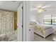 Bright bedroom adjoins to the bathroom with shower and bathtub with coastal-themed curtain at 175 Kings Hwy # B5, Punta Gorda, FL 33983