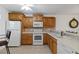 Charming kitchen with wooden cabinets, white appliances, and tiled backsplash at 175 Kings Hwy # B5, Punta Gorda, FL 33983