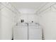 Efficient laundry area featuring a washer and dryer set with overhead storage racks for organized living at 175 Kings Hwy # B5, Punta Gorda, FL 33983