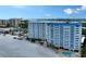 Aerial view of beachfront condominiums with pools, surrounded by lush landscaping and sandy shores at 1750 Benjamin Franklin Dr # 6F, Sarasota, FL 34236