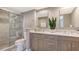 Modern bathroom featuring double vanity, marble countertops, glass shower, and neutral tones at 1750 Benjamin Franklin Dr # 6F, Sarasota, FL 34236