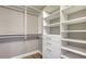 Organized walk-in closet with white built-in shelves and drawers, maximizing storage space at 1750 Benjamin Franklin Dr # 6F, Sarasota, FL 34236