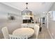 Dining area featuring a round white table, four chairs, and an elegant chandelier at 1800 Gulf N Dr # 112, Bradenton Beach, FL 34217