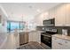 Well-equipped kitchen with stainless steel appliances and an adjacent dining area with an ocean view at 1800 Gulf N Dr # 112, Bradenton Beach, FL 34217