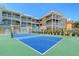 Exterior shot of building with tennis court and tropical landscape at 1800 Gulf N Dr # 112, Bradenton Beach, FL 34217