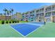 Exterior shot of building with tennis court, tropical landscape, and balconies at 1800 Gulf N Dr # 112, Bradenton Beach, FL 34217