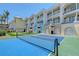 Backyard with seating area, manicured lawn, and a tennis court at 1800 Gulf N Dr # 112, Bradenton Beach, FL 34217