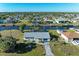 Aerial view of a waterfront home featuring a large yard, screened lanai, and boat dock at 18082 Eau Gallie S Cir, Port Charlotte, FL 33948