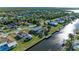 Aerial view of waterfront homes along a canal with a nearby river or ocean at 18082 Eau Gallie S Cir, Port Charlotte, FL 33948