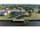 Aerial view of a home with a screened lanai, a boat dock, and easy access to the canal at 18082 Eau Gallie S Cir, Port Charlotte, FL 33948