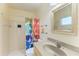 Well-lit bathroom with an oatmeal-colored vanity, mirror, and shower with colorful curtain at 18082 Eau Gallie S Cir, Port Charlotte, FL 33948