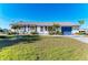 Charming single-story home with manicured lawn, blue shutters, and a matching blue garage door at 18082 Eau Gallie S Cir, Port Charlotte, FL 33948